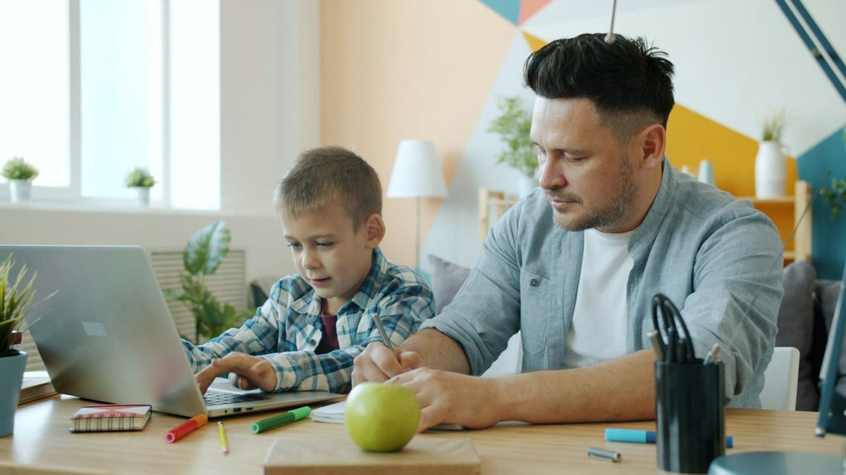 Un papá y su hijo trabajando juntos en una mesa